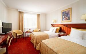 a hotel room with two beds and a television at Hotel Mazurkas in Ożarów Mazowiecki