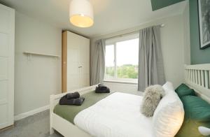 ein Schlafzimmer mit einem weißen Bett und einem Fenster in der Unterkunft Stunning 5 bed house in Chapel Allerton, sleeps 9 in Moortown