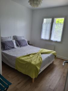 een slaapkamer met een bed met een gele deken erop bij Le Clos Saujonnais 2 in Saujon