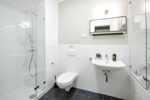 a bathroom with a toilet and a sink and a shower at limehome Budapest Mosonyi u in Budapest