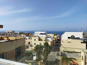 Vue sur une ville avec l'océan en arrière-plan dans l'établissement Duplex penthouse with swimming pool, à Xgħajra