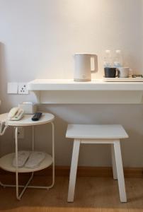 a white counter with a table and two stools at Ole Tai Sam Un Hotel in Macau