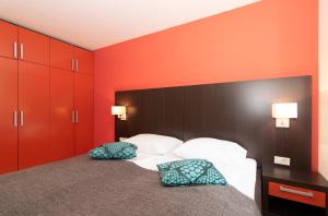 a bedroom with red walls and a bed with two pillows at Residence Marina Garbin Apartment in Portorož