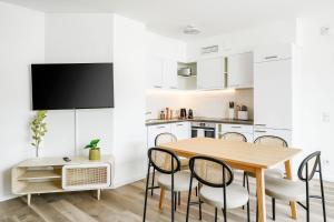 a kitchen and dining room with a wooden table and chairs at limehome Budapest Mosonyi u in Budapest