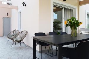 a dining room table with chairs and a vase of flowers at Aegean Dreams Villa Palio in Paleo Tsifliki