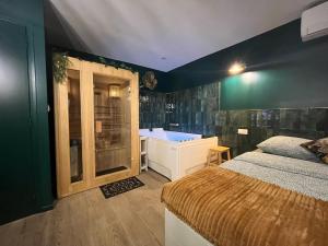 a bedroom with a bed and a tub and a sink at Le SPEAK EASY / JACUZZI ET SAUNA in Marseille