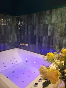 una bañera púrpura con flores en una habitación en Le SPEAK EASY / JACUZZI ET SAUNA, en Marsella