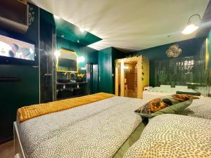 a bedroom with two beds and a bathroom with a sink at Le SPEAK EASY / JACUZZI ET SAUNA in Marseille