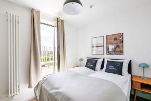 a white bedroom with a bed and a window at limehome Budapest Mosonyi u in Budapest