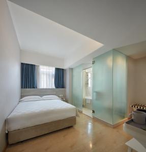 um quarto com uma cama grande e uma parede de vidro em Ole Tai Sam Un Hotel em Macau