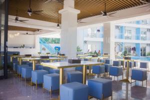 a dining room with tables and blue chairs at Bohol Dolphin Bay Resort in Panglao