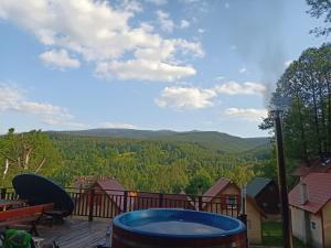 a deck with a hot tub and a view of the mountains at Grzywaczówka in Przesieka