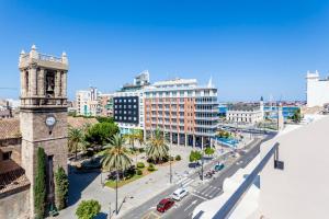eine Stadt mit einem Uhrturm und einer Straße in der Unterkunft Puerto Beach suites in Valencia