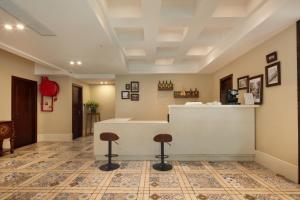 a lobby with a counter and two stools at Ole Tai Sam Un Hotel in Macau