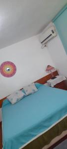 a bedroom with a bed with a blue bedsheet at DEPARTAMENTO Carlos paz próximo Costanera y autopista in Villa Carlos Paz