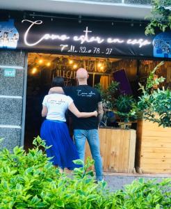 a man and a woman standing outside of a store at Casa Egos Pop Laureles in Medellín