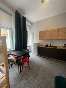 a kitchen with a black table and a red stool at Hostel Plac Kolegiacki in Poznań