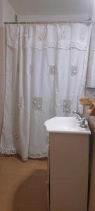 a bathroom with a white shower curtain and a sink at DEPARTAMENTO Carlos paz próximo Costanera y autopista in Villa Carlos Paz