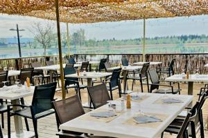 restauracja ze stołami i krzesłami z widokiem na wodę w obiekcie Appartement avec balcon/terrasse w mieście Monteux