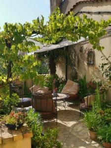 un patio con mesa, sillas y plantas en 'Quelle Belle Vue' Chambre d'Hote, en Confolens