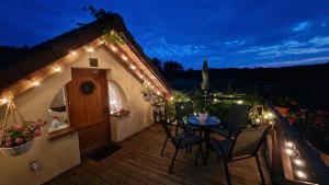 een patio met een tafel en stoelen op een terras met verlichting bij Szumi Las in Szumles Królewski