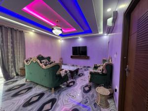 a room with two chairs and a tv and purple ceilings at Hotel Yog Safari in Rishīkesh