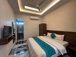 1 dormitorio con 1 cama grande y TV en Hotel Yog Safari en Rishīkesh