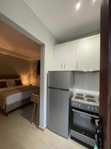 a kitchen with a stove and a bed in a room at Barbara’s House,New Superior Central Studio in Nea Kallikrateia
