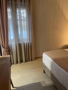 a bedroom with a bed and a window with curtains at Barbara’s House,New Superior Central Studio in Nea Kallikrateia