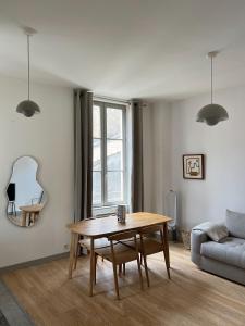 a living room with a table and a couch at Maison Lumière - Appart. T2 architecte intra-muros in Avignon