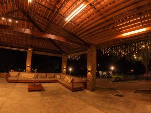 a patio with couches under a wooden ceiling with lights at Hotel Fazenda Pedra Do Rodeadouro in Bonito