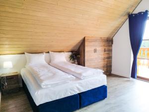 a large bed in a room with a wooden ceiling at Wierchy Beskidu in Dobra