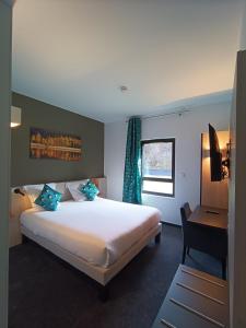 a hotel room with a large bed and a desk at Hôtel Restaurant AKENA Molinges - La Brocatelle in Saint-Claude