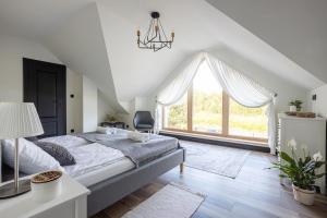 - une chambre avec un lit et une grande fenêtre dans l'établissement Cisza Spokój - Mazury, 