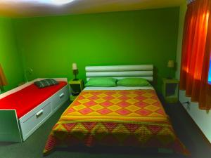 een groene slaapkamer met een bed en een rode muur bij B&B Casa Linda in Pradipozzo