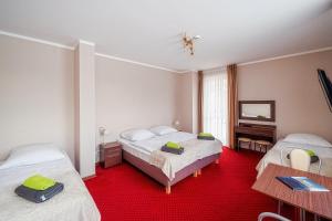 a hotel room with two beds and a television at Villa Gronie Ski & Bike in Szczyrk