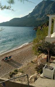 a person laying on a beach next to the water at Apartmani Martinovka in Drašnice