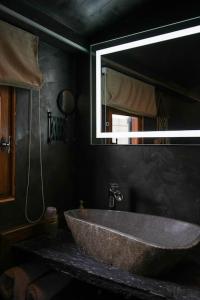um grande lavatório de pedra na casa de banho com espelho em Chalet, lodge, Cottage, avec spa au bord de l'eau em Prouilly