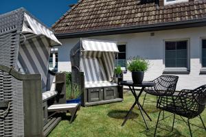a backyard with a grill and a table and chairs at Villa am Meer in Westerland (Sylt)