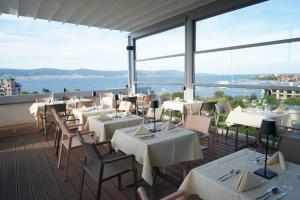 un restaurante con mesas y sillas y vistas al agua en Sol Marina Palace Hotel All Inclusive Adults Only, en Nesebar