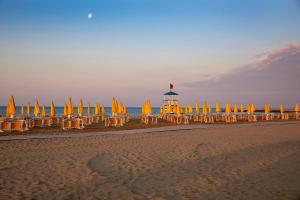 a group of chairs and umbrellas on a beach at Camping Village Garden Paradiso in Cavallino-Treporti