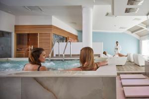two women in a hot tub in a room at Camping Village Garden Paradiso in Cavallino-Treporti