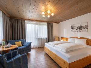 ゲルロスにあるPension Zillertalのベッドとソファ付きのホテルルーム