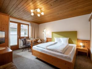 een slaapkamer met een groot bed en een bureau bij Pension Zillertal in Gerlos