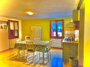 a kitchen with a table with chairs and a refrigerator at B&B Casa Linda in Pradipozzo