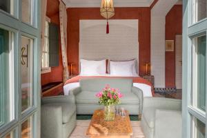 馬拉喀什的住宿－瑞茲蘭德博宮酒店及SPA，一间卧室配有一张床、一张沙发和一张桌子