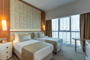 Un pat sau paturi într-o cameră la Grand Bellagio Batumi Convention & Casino Hotel