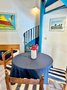 une table bleue avec un vase de fleurs sur elle dans l'établissement Appartamento del Pescatore, à Castellabate