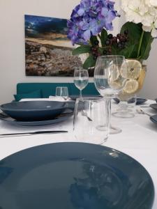 a table with plates and glasses and a vase of flowers at Cuocciu ri zuccuru in Scicli