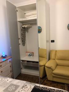 een spiegel in een slaapkamer met een bank en een stoel bij Sensory Garden in San Daniele del Friuli